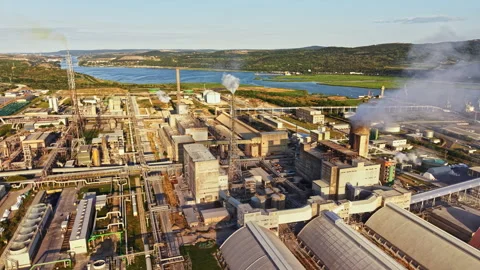 Factory operates near river with smoke and water in the background during Stock Footage 340962253