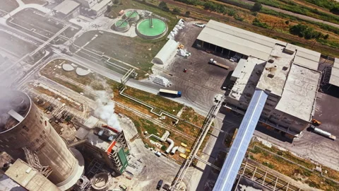Factory operates with smoke rising from chimneys and a truck arriving at the Stock Footage 341397953
