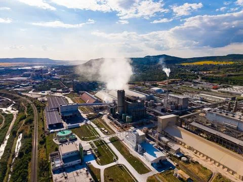 Factory in operation during daytime with smoke rising from chimneys and sur.. Stockfoto's