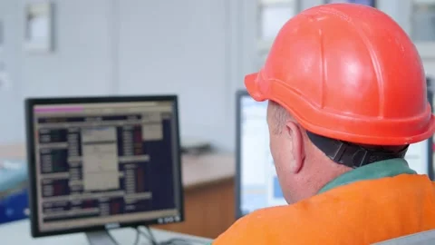 Factory operator in a helmet at work near computer Stock Footage 136483411