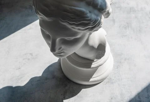Factory plaster bust of Aphrodite on a textured concrete surface in bright .. Fotos Stock