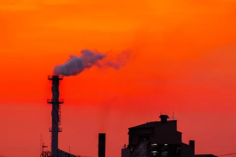 The factory released smoke chimney in sunset. Global warming concept Stock Photos