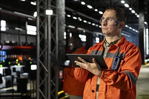 Factory staff uses workshop tools and tablet to inspect steel components Stock Photos