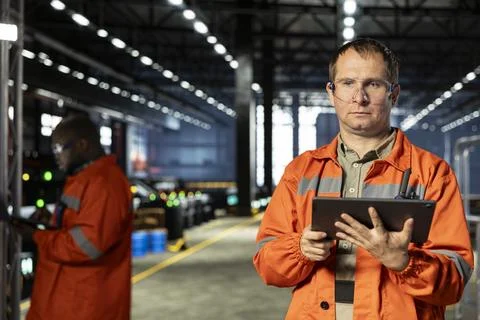 Factory staff uses workshop tools and tablet to inspect steel components Stock Photos