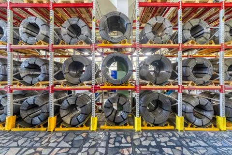 Factory stock wire. Wire spools lie on multi-tiered racks. Stock Photos