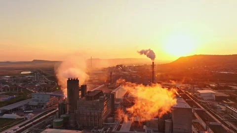 Factory at sunset with smoke rising and machinery visible in the background Stock Footage 340945449