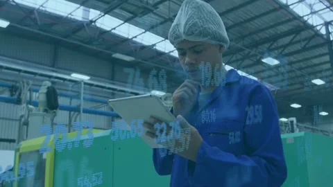 Factory tech tapping tablet and checking machine data while blue overlay moving Stock Footage 335465590