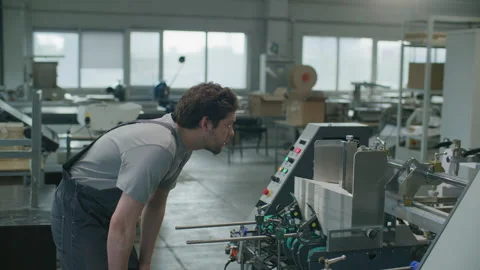 Factory Technician Operating Industrial Printing Machine with Computer Stock Footage 335484376