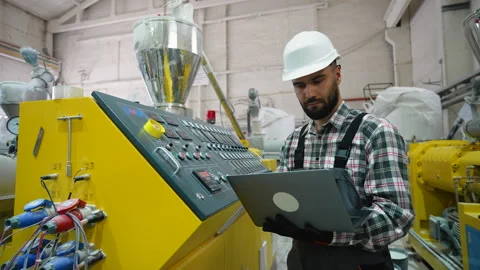 Factory technician operating machinery with laptop Stock Footage 314583129