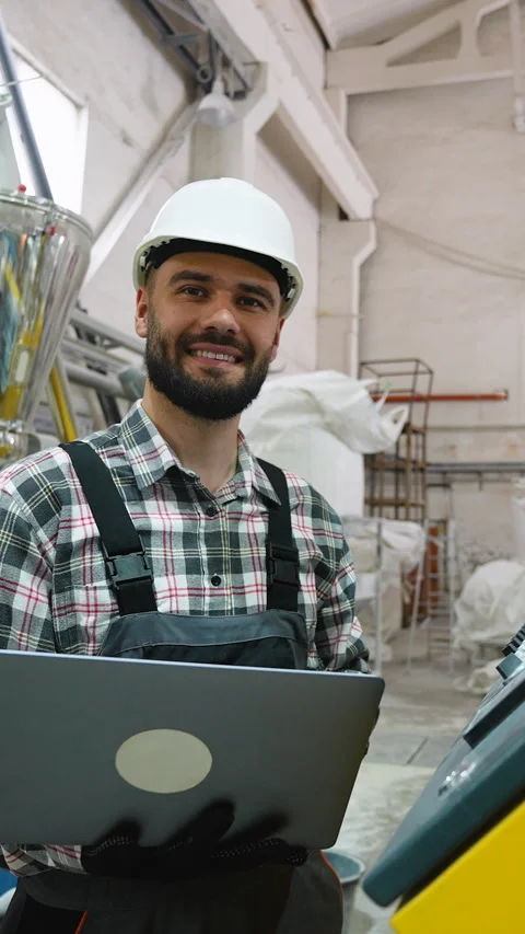 Factory technician operating machinery with laptop Stock Footage 314584664
