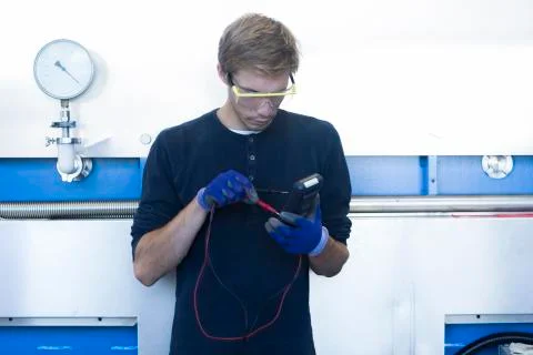 Factory technician testing cable in factory Stock Photos