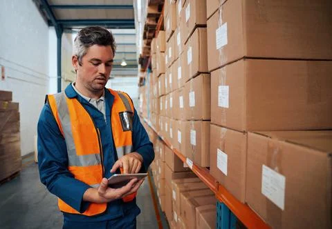 Factory technician working using digital tablet at factory warehouse Stock Photos