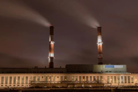 Factory with two smoke stack against sky at night Stock Photos