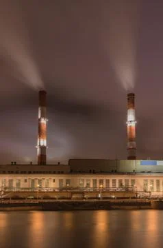 Factory with two smoke stack against sky at night Stock Photos