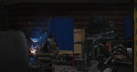 Factory welder welds pipe Stock Footage 104028552
