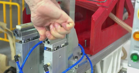 Factory worker adjusting industrial pneumatic machine Stock Footage 327129707