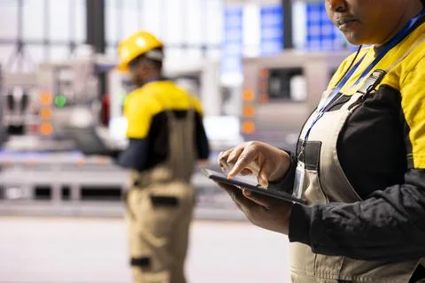 Factory worker analyzing data on tablet Stock Photos