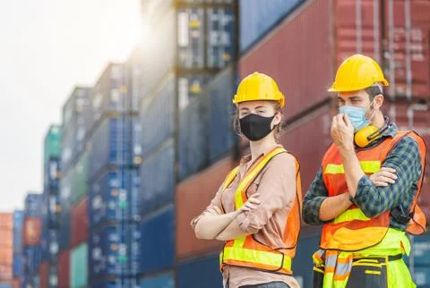 Factory worker and engineer team wearing protection face mask standing in line Fotos Stock