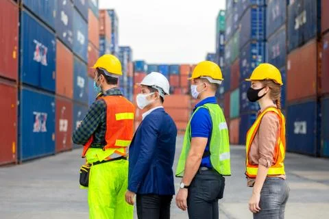 Factory worker and engineer team wearing protection face mask standing in line Foto stock
