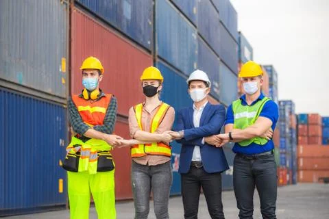 Factory worker and engineer wearing protection face mask, Team holding hands Fotos de archivo