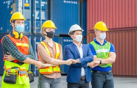 Factory worker and engineer wearing protection face mask, Team holding hands Photos