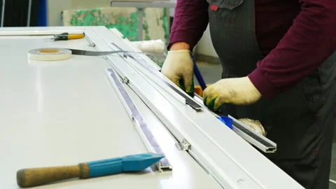 Factory worker assembling a metal door frame Stock Footage 317099518