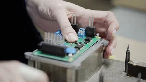 A factory worker attaches electrical components to the board Stock Footage 213720406