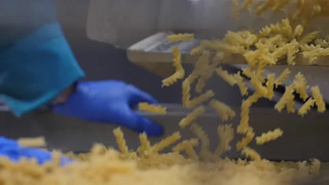 Factory worker in blue gloves checks a fine macaronis quality on the conveyor Stock Footage 160449427