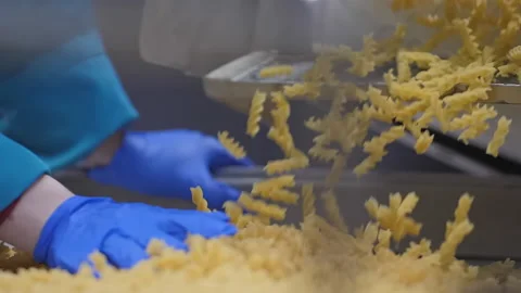 Factory worker in blue gloves checks a fine macaronis quality on the conveyor Stock Footage 163311720