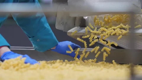 Factory worker in blue gloves checks a fine macaronis quality on the conveyor Video stock 163394657