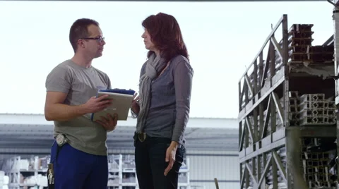 Factory worker chatting with lady about wonderful stuff Stock Footage 63016248