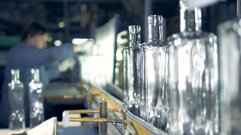 Factory worker is checking quality of glass bottles moving along the conveyor Stock Footage 89977828