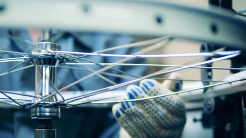 Factory worker is checking spokes in a bicycle wheel Vídeo Stock 146637393