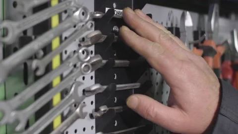 A factory worker chooses the right tool among others at his organized workbench Stock Footage 147254658