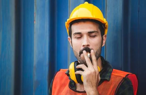 Factory worker with a cigarette smoke break, Labour takes a cigarette break Фото