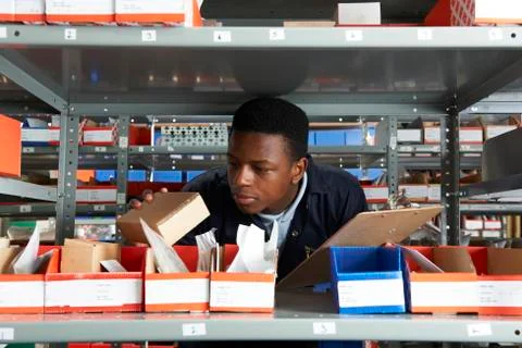 Factory worker with clipboard in storeroom Stock Photos