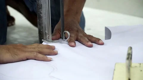 Factory worker cutting of fabric in factory. Used the razor machine for cutti Stock Footage 166046174