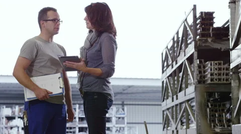 Factory worker discussing business while looking at a tablet. Stock Footage 63018401