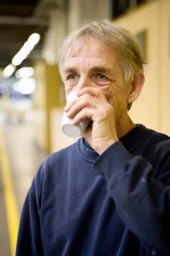 Factory worker drinking cup of coffee Stock Photos
