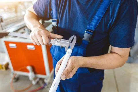 Factory worker engineer checks the quality of polypropylene pipes Stock Photos
