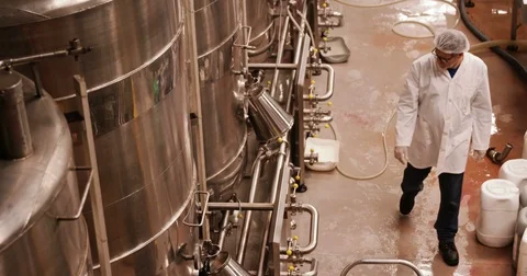 Factory worker examining storage tanks Stock Footage