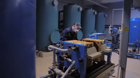 Factory Worker in a Facemask Cleaning Dirty Filters on an Industrial Machine Stockbeeldmateriaal 278041104
