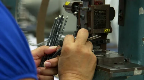 A factory worker feeds wire into a machine Видео 49177236