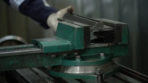 A factory worker fixes an iron object in a bench vise Stock Footage 122244527