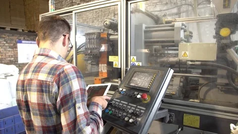 Factory worker in glasses with tablet controls the operation of the hydraulic Stock Footage 77820887