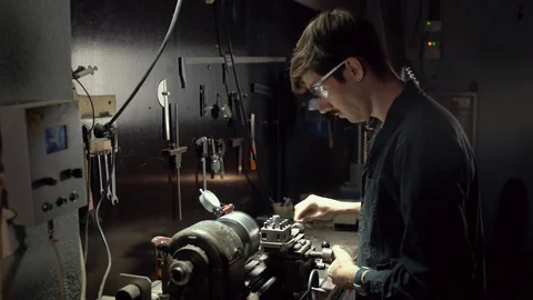 Factory worker in glasses is working a milling machine at factory. The concept Stock Footage 128752429