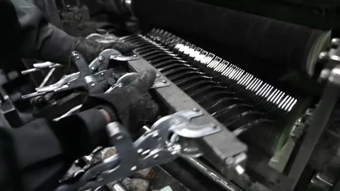 Factory worker handling bar of clamped fork blanks coated with polishing Stock Footage 340277724