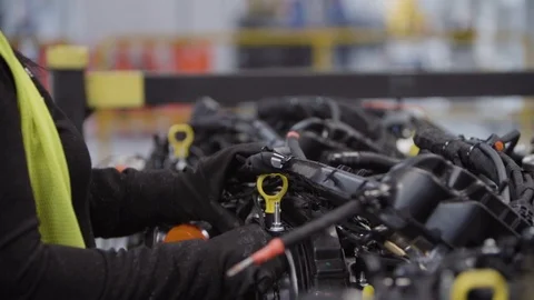 Factory worker inside an automotive manufacturing plant. Working on a car engine Video stock 127040428