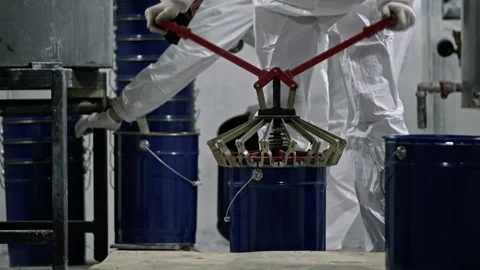 Factory worker lifting paint bucket using machine Vídeo Stock 293692762