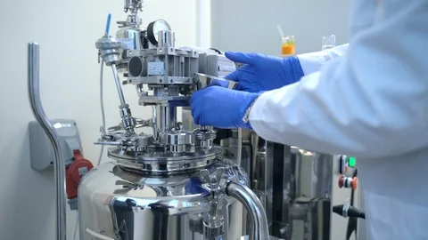 Factory worker loading pouring chemical liquid into medicine production machine Stock Footage